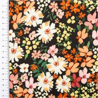 Stoff mit Blumenmuster in Orange und Weiss auf schwarzem Hintergrund, mit Meterstab links.