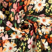 Bunter Blumenstoff, gedreht, zeigt lebendige Farben und florales Muster.