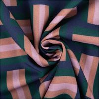 Detailaufnahme des Stoffmusters mit geometrischen Formen in Blau, Grün und Rosa.