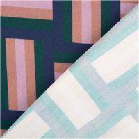 Nahaufnahme von Stoff mit geometrischem Muster in Rosa, Grün, Blau und Beige.