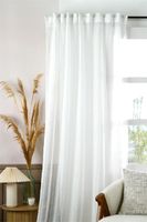 Weißer Voile-Vorhang am Fenster mit Sessel und Lampe, luftige Einrichtung