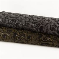 Paillettenstoff Ornamente Spitze gold schwarz 1,25m Breite zwei Ballen aus schwarzem Stoff mit goldenen und silbernen Ornamenten übereinandergelegt