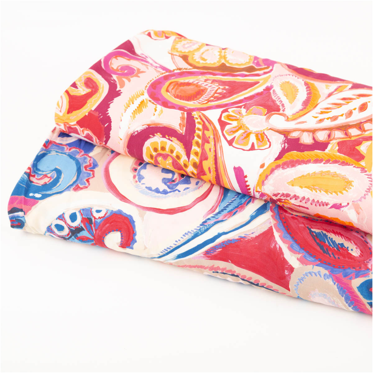 Viskosestoff Paisley Ornamentmuster in Rosa und Blau als gefalteter Stoffstapel
