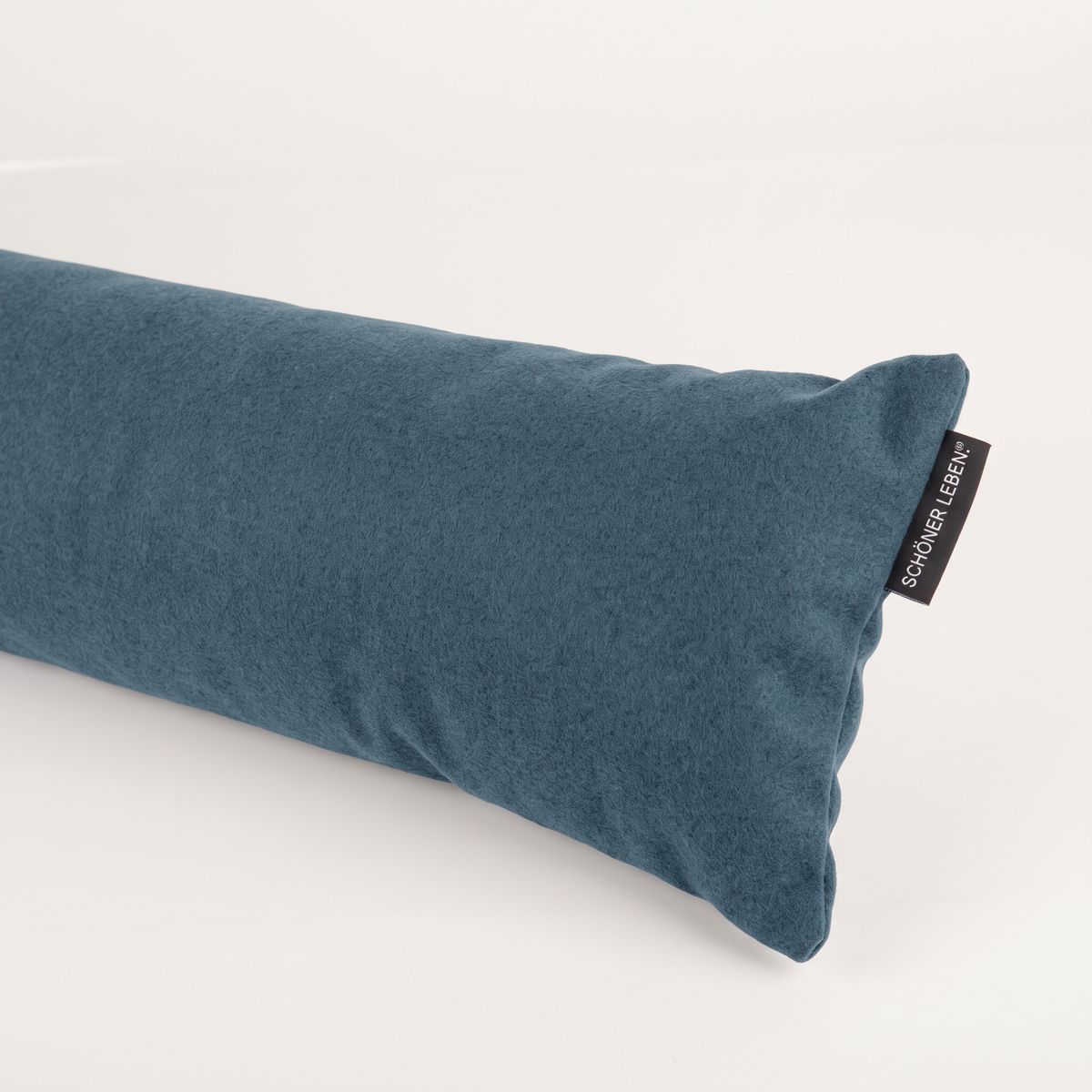 blauer Thermo-Zugluftstopper aus Fleece liegt schräg auf hellem Hintergrund, Detailansicht Material