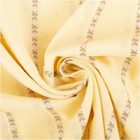 gefalteter gelber Baumwollstoff mit Blümchen und Streifen, zur Spirale gelegt, Muster in Rosa und Grün