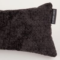 Nahaufnahme eines dunkelgrauen Kissens aus Teddy-Stoff mit sichtbarem SCHÖNER LEBEN. Label