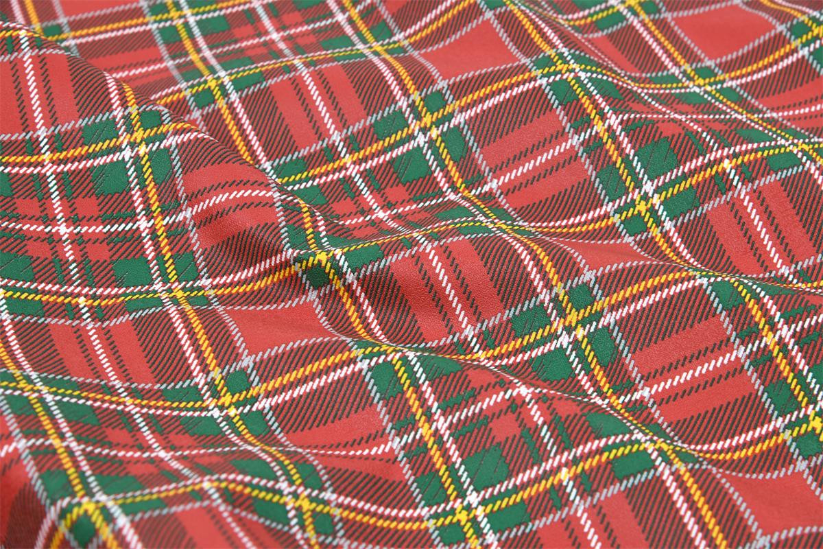 Abwaschbarer Tischdeckenstoff mit rot-grünem Tartan-Karo, Makroaufnahme der Oberfläche.