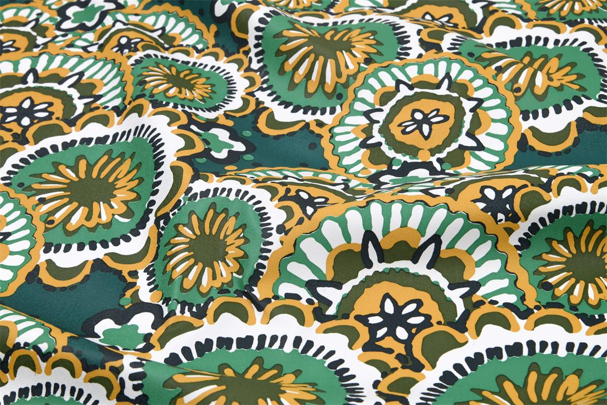 Abwaschbarer Tischdeckenstoff mit Mandalas in Petrol, Senfgelb und Mint, Makroaufnahme der Oberfläche.
