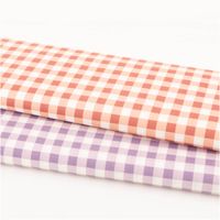 zwei Baumwollstoffe mit Karo-Muster in Apricot-Rot und Flieder nebeneinander gelegt