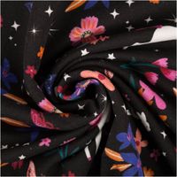 French Terry Stoff mit bunten Blumen und Einhörnern auf schwarzem Hintergrund, spiralig gedreht