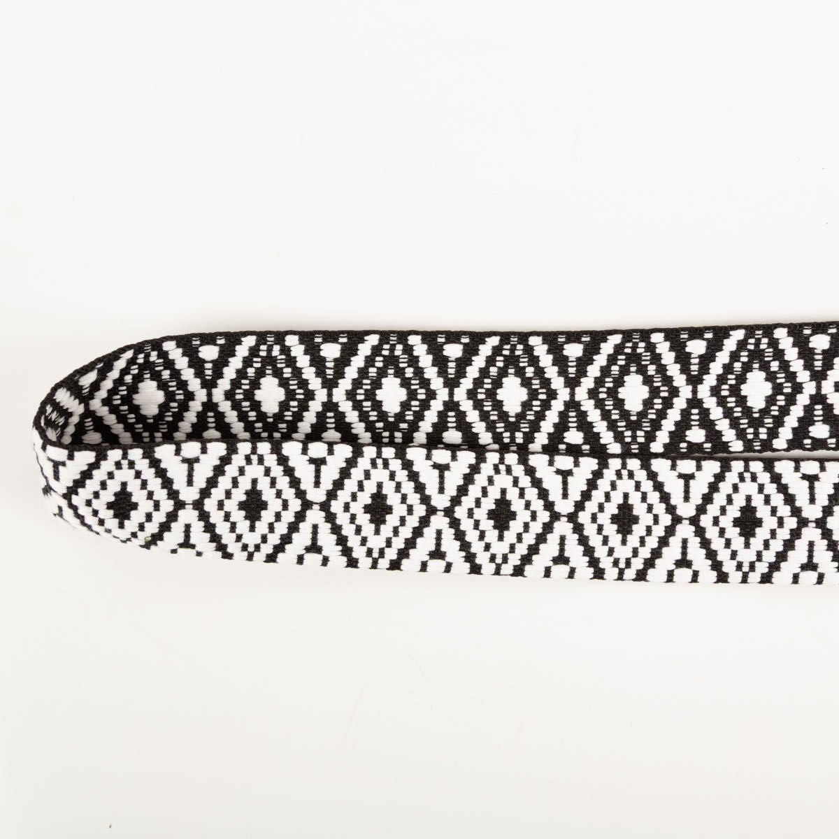 Gurtband Ethno Rautenmuster schwarz weiß 3,8cm Breite Nahaufnahme von Gurtband in Schwarz-Weiß mit Ethno-Rautenmotiv auf weißem Hintergrund