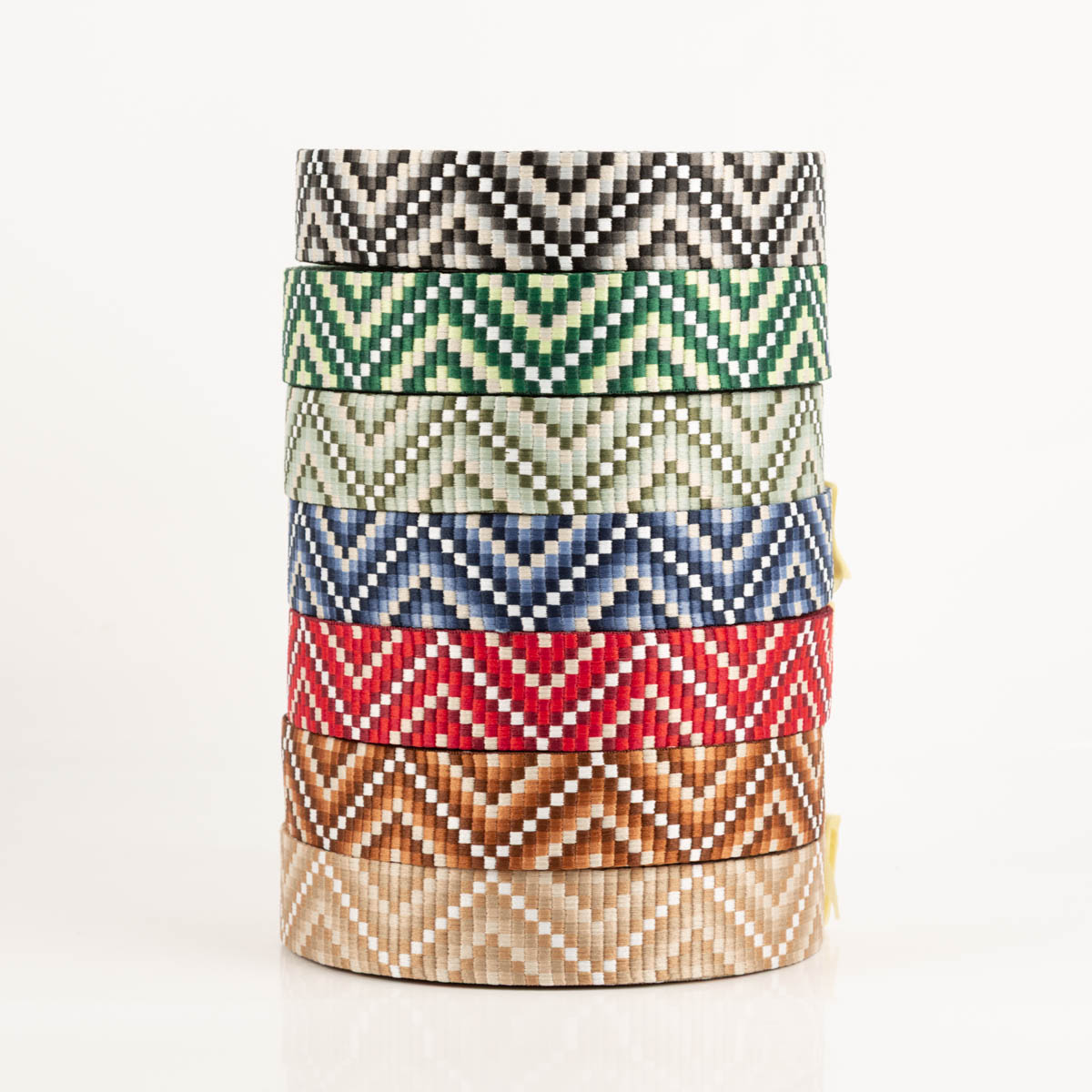 Gurtband Zickzack Chevron rot beige weiß 3,8cm Breite Stapel mit sechs Gurtbändern im Zickzack-Design, verschiedene Farben aufeinandergelegt auf weißem Hintergrund