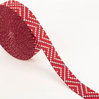 Gurtband Zickzack Chevron rot beige weiß 3,8cm Breite Gurtband mit Zickzack-Muster in rot, beige und weiß, als Rolle abgewickelt auf hellem Hintergrund