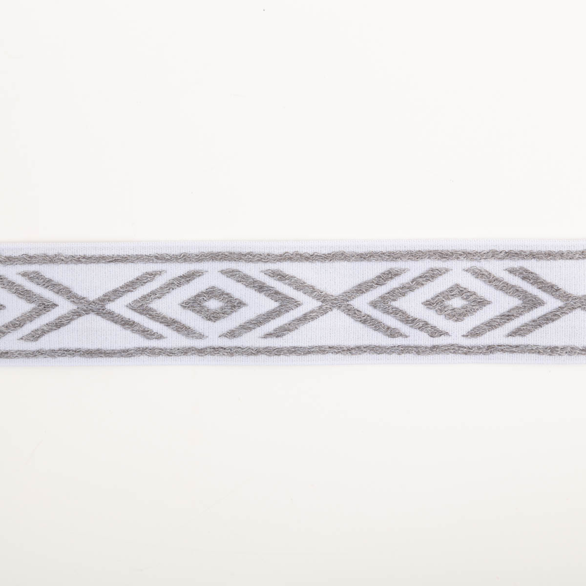 Gummiband Glitzer Rauten geometrisch weiß silber 4cm Breite elastisches Band in Weiß mit silberfarbenem geometrischen Muster, flach ausgebreitet auf weißem Hintergrund