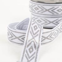 Gummiband Glitzer Rauten geometrisch weiß silber 4cm Breite glänzendes Elastikband in Weiß mit silbernen Rauten, dekorativ in Kurven gelegt, Nahaufnahme