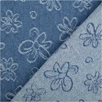 Vorder- und Rückseite eines Jacquardstoffs mit blauen und weißen Blumenmotiven nebeneinander liegend