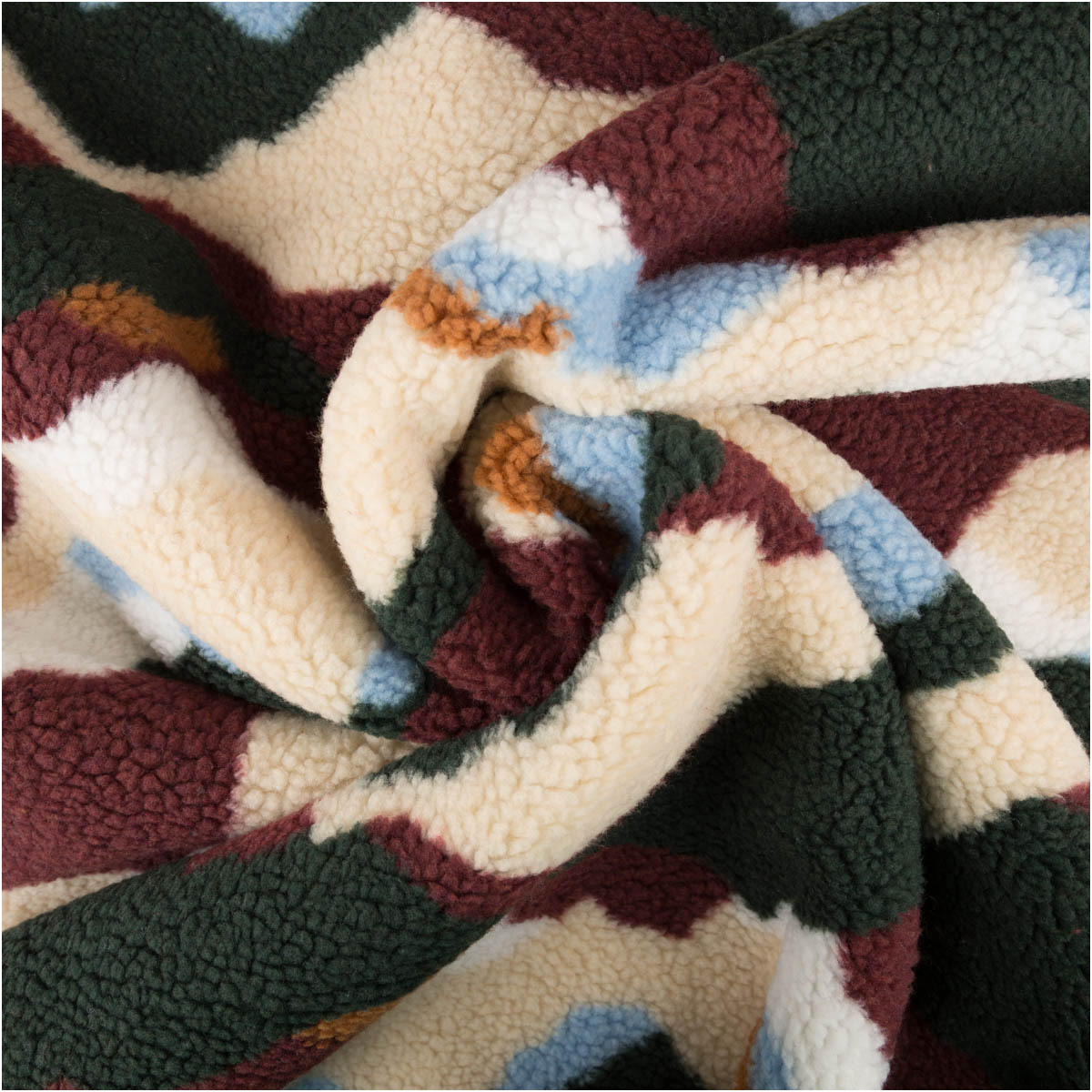 Teddy Stoff Sherpa Fleece abstrakte Wellen bordeauxrot bunt 1,50m Breite Sherpa Fleece Stoff abstrakte Muster in bordeauxrot, creme, grün und hellblau zur Spirale gelegt