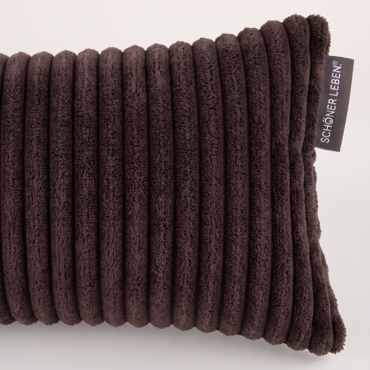 Makroaufnahme der breiten Cordrippen in Coffee Braun mit schwarzem Textiletikett von SCHÖNER LEBEN.