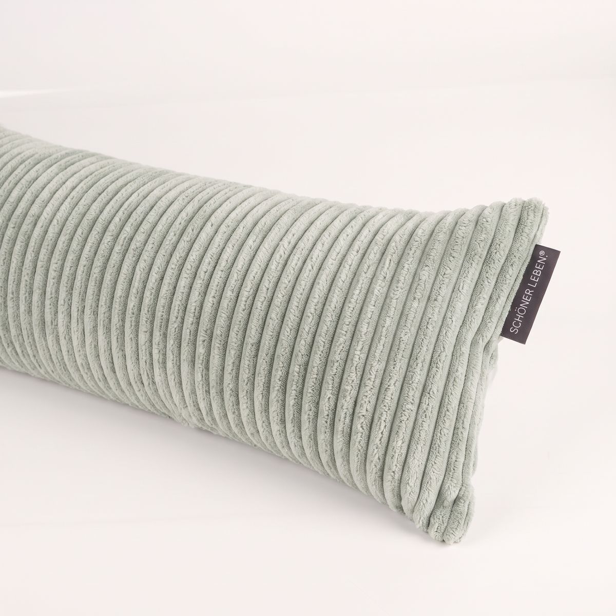 Nahaufnahme eines Zugluftstoppers aus Breitcord Baby Rib in Mintgrün mit Stoffetikett von SCHÖNER LEBEN. Nahaufnahme eines Zugluftstoppers aus Breitcord Baby Rib in Mintgrün mit Stoffetikett von SCHÖNER LEBEN.