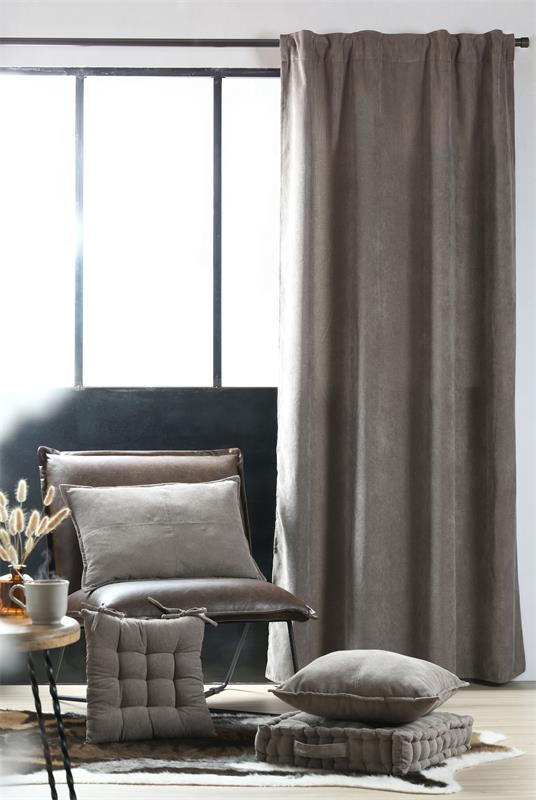 Thermovorhang in Taupe am Fenster eines Wohnraums mit Sessel, Kissen und Beistelltisch
