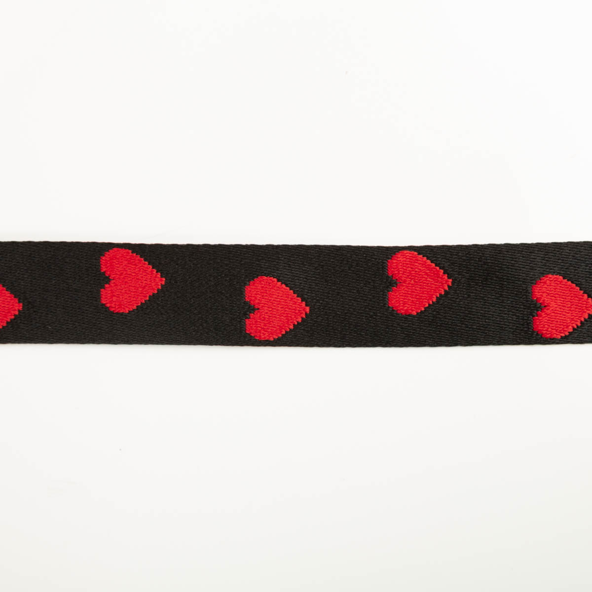 Gurtband Herzen schwarz rot Breite: 4cm Schwarzes Band mit roten Herzmotiven, gerade ausgebreitet auf weißem Hintergrund