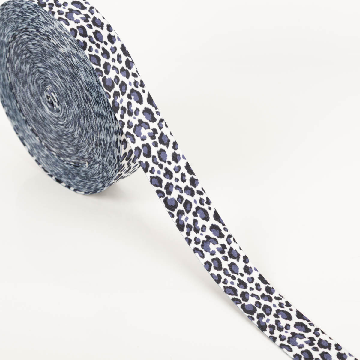 Gurtband Leopard weiß dunkelblau Breite: 4cm Gurtband mit dunkelblauem Leopardenmuster auf weißem Grund, aufgewickelt zur Rolle