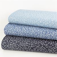 Jeansstoff Leo Leomuster bedruckt dunkelblau hellgrau 1,5m Breite drei unterschiedlich dunkelblaue Jeansstoffe mit Leomuster, als Stapel gelegt, Motiv und Struktur gut erkennbar