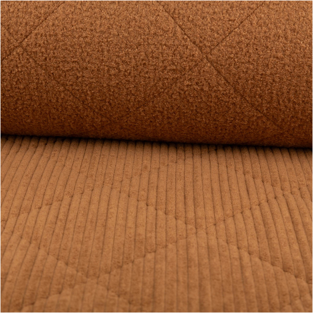 Nahaufnahme von Steppstoff aus Cord und Teddy in camel mit grober Rippenstruktur und sichtbarer Steppung