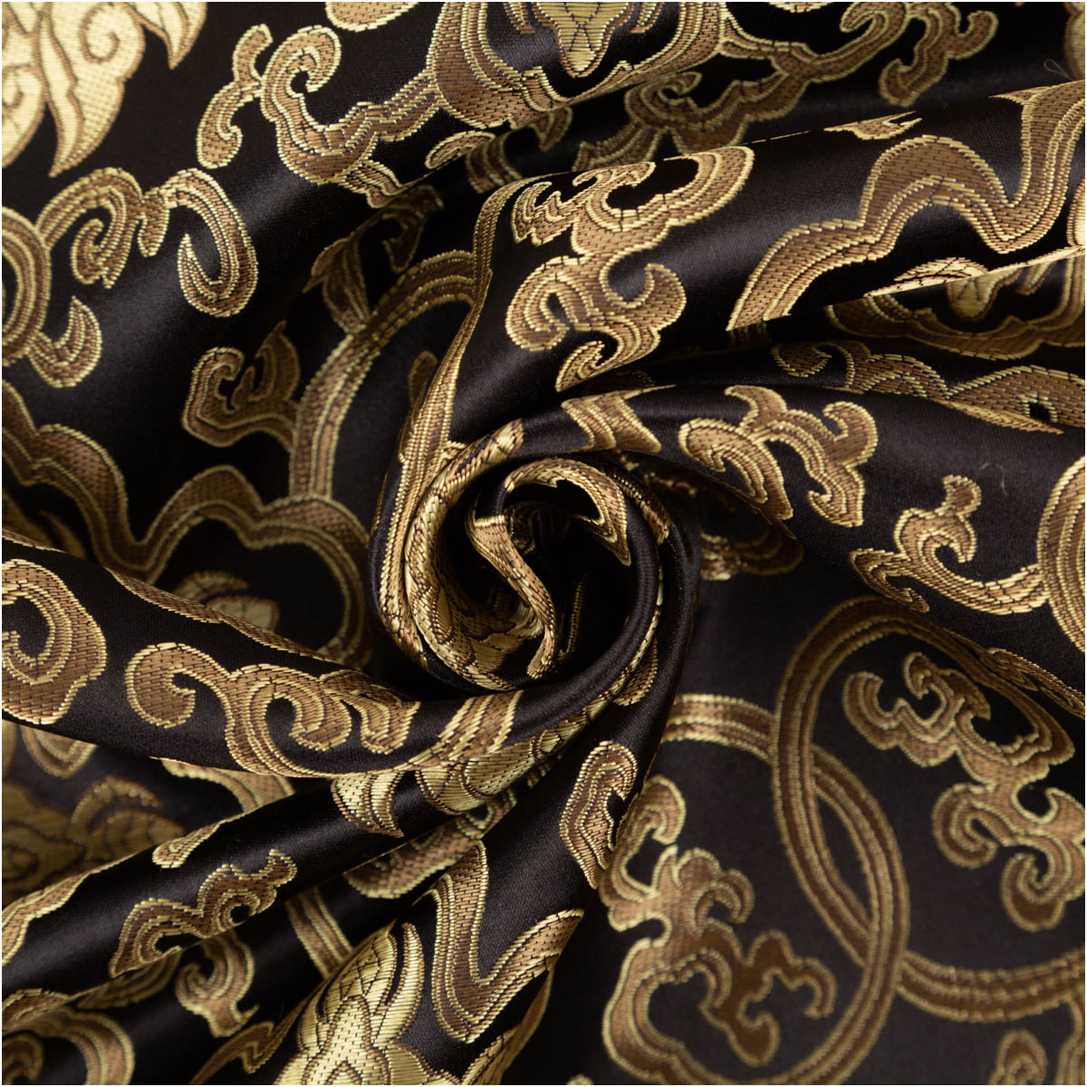 schwarzer Brokatstoff mit goldfarbenen Ornamenten, zur Spirale gedreht, Muster und Glanz im Detail sichtbar