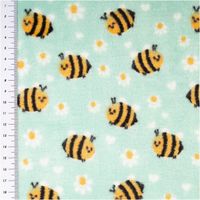 grüner Fleece mit gelb-schwarzen Bienen und weißen Blüten, Stoffdetail mit Lineal zur Maßangabe