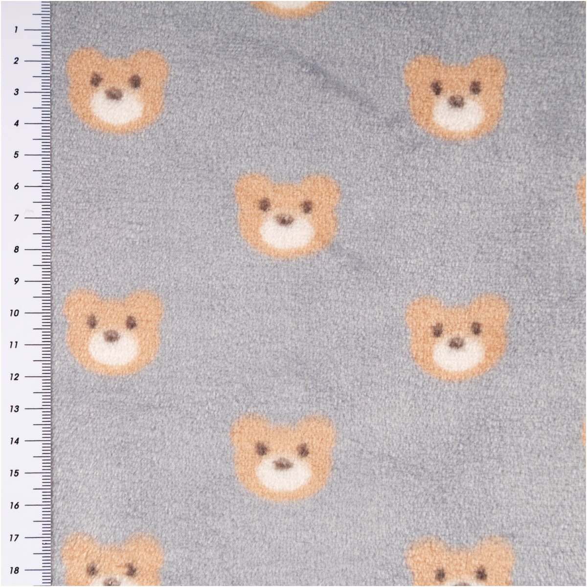 Fleece Stoff in Grau mit braunen Teddybär-Gesichtern, Nahaufnahme, links Maßband sichtbar