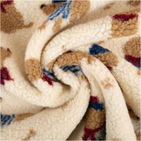 cremefarbener Jacquardplüsch mit braunen und blauen Dackelmotiven, zur Spirale gedreht