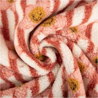Weicher Teddyplüschstoff mit rosa und korallefarbenen Streifen sowie gelben Blumen zur Spirale gelegt