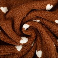 in Spirale gelegter brauner Teddystoff mit eingestickten cremefarbenen Herzen, Strukturoptik erkennbar