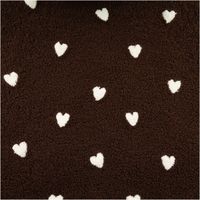 Nahaufnahme von schokobraunem Teddystoff mit cremefarbenen, bestickten Herzmotiven