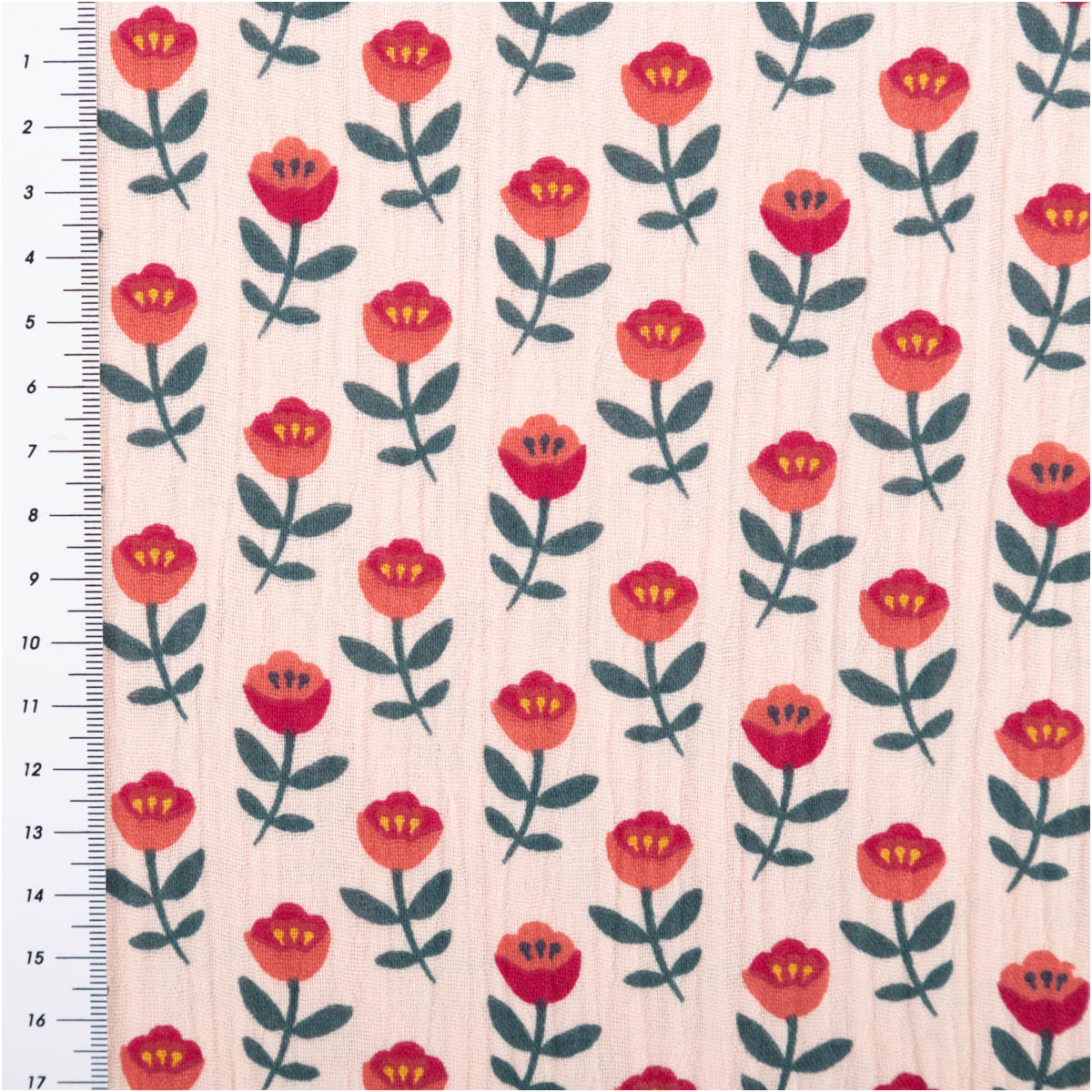 Musselinstoff mit rosa Blütenmuster, Baumwolle mit roten Blüten und dunkelgrünen Blättern, Maßband am Rand