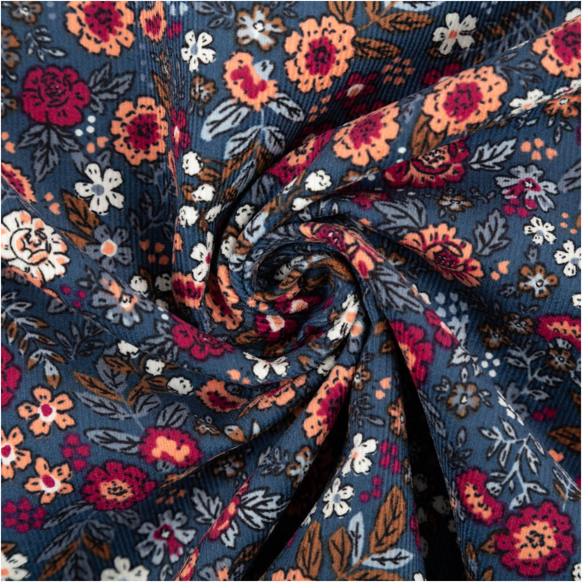 Cord Stoff Feincord Barjay Streublumen petrol rosa 1,45m Breite Feincordstoff in Petrolfarben zur Spirale gelegt, Blumenmuster in Rosa, Orange und Weiß deutlich sichtbar