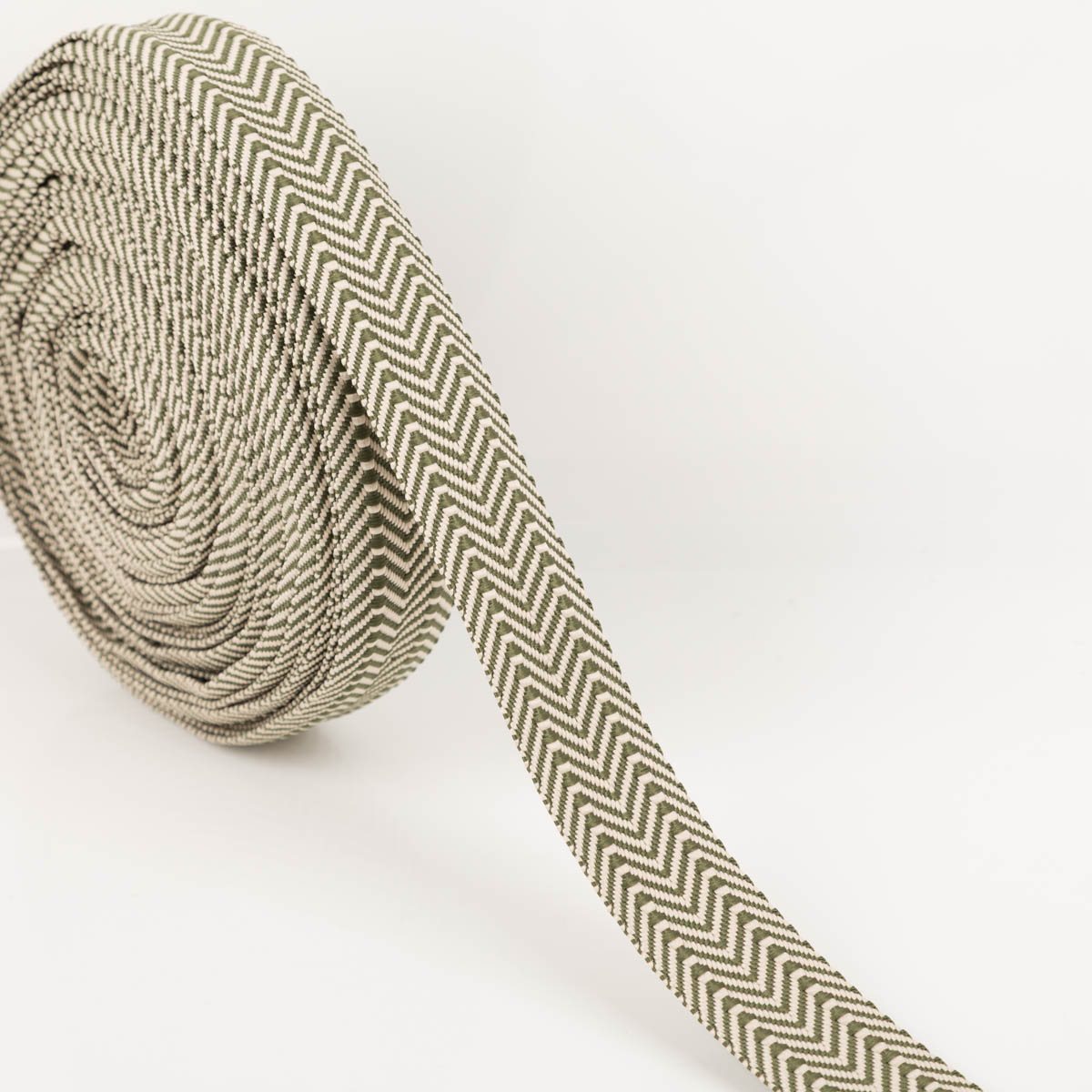 Gurtband doppeltes Zickzack khaki 3,8cm auf der Rolle, abgewickeltes Band zeigt das gewebte doppelte Zickzackmuster