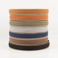 Gurtband Fischgrat 4cm Breite: sieben Rollen gestapelt in Cognac, Ziegelrot, Oliv, Hellgrau, Blau, Braun, Schwarz