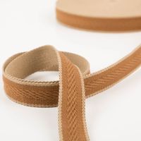 Gurtband Fischgrat cognac 4cm zur Schlaufe gelegt vor der Rolle, beigefarbene Rückseite sichtbar