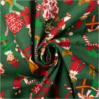 grüner Baumwollstoff mit Weihnachtsmotiven und Elfen zur Spirale gedreht