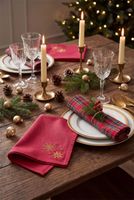 Gefaltete rote Stoffservietten auf festlich gedecktem Weihnachtstisch Gefaltete rote Stoffservietten auf festlich gedecktem Weihnachtstisch